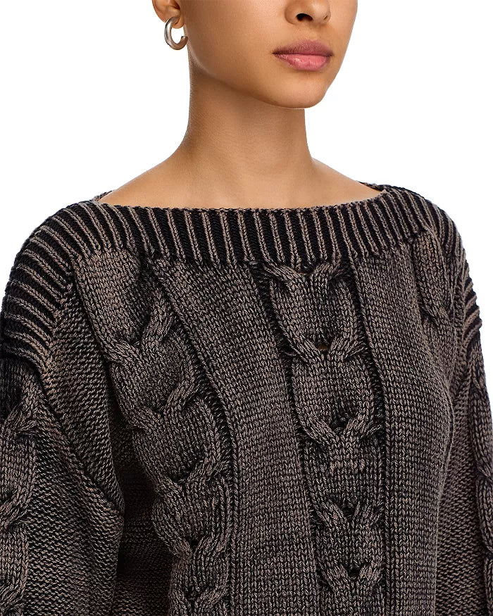 Close-up of a person wearing a dark gray cable knit sweater on a white background