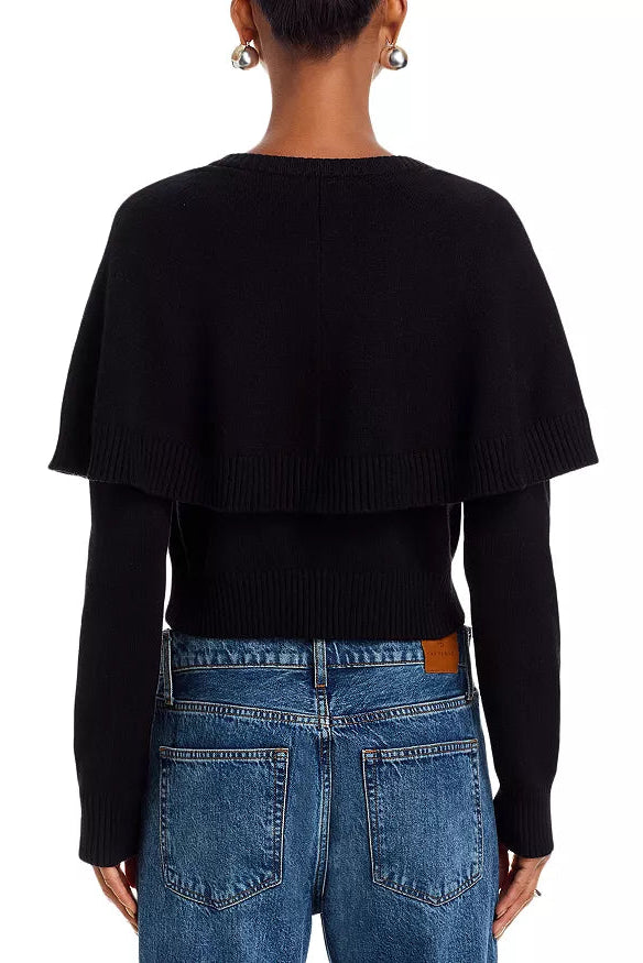 Person wearing a black sweater and blue jeans on a white background