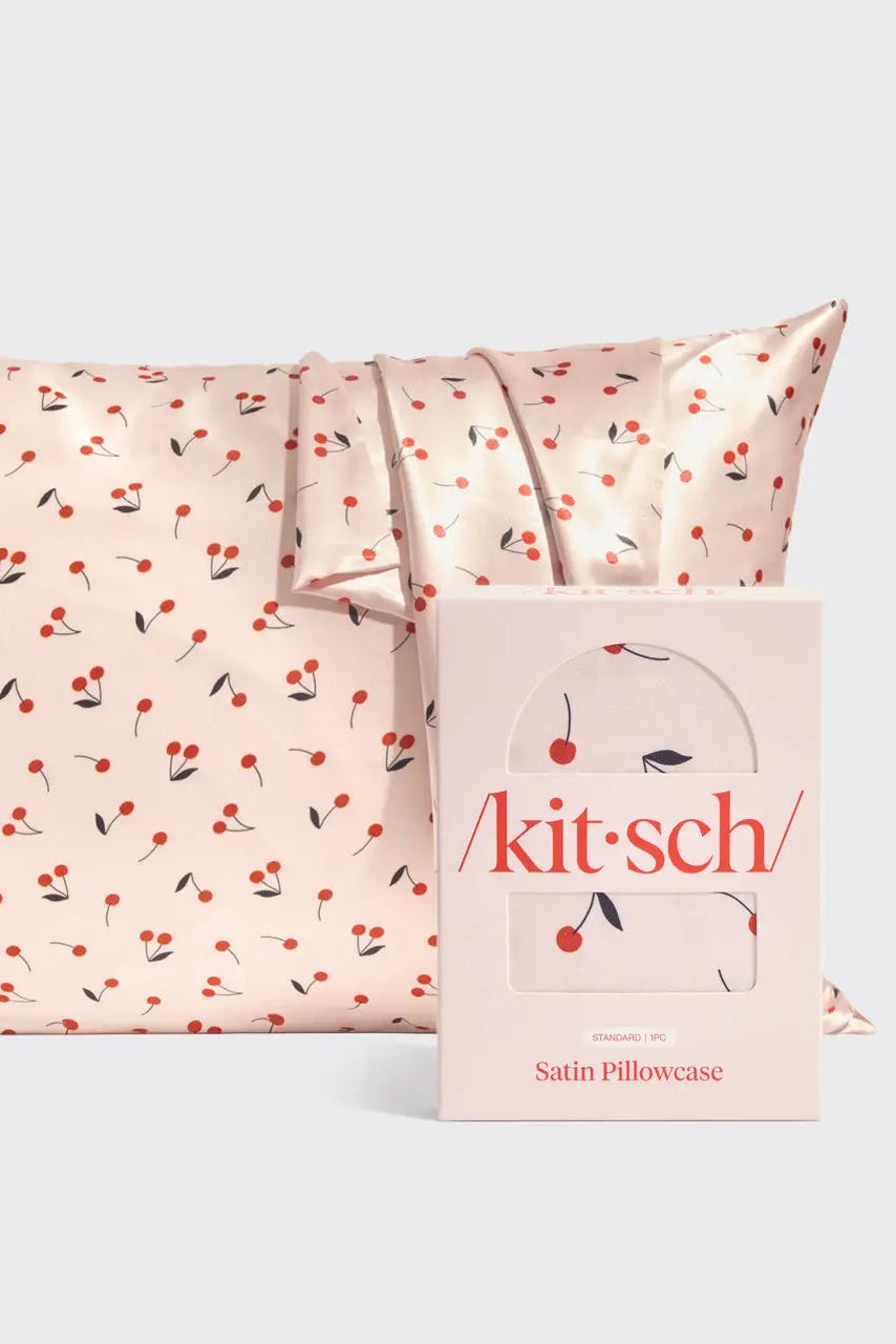 Satin pillowcase with cherry pattern and 'kitsch' packaging on a white background