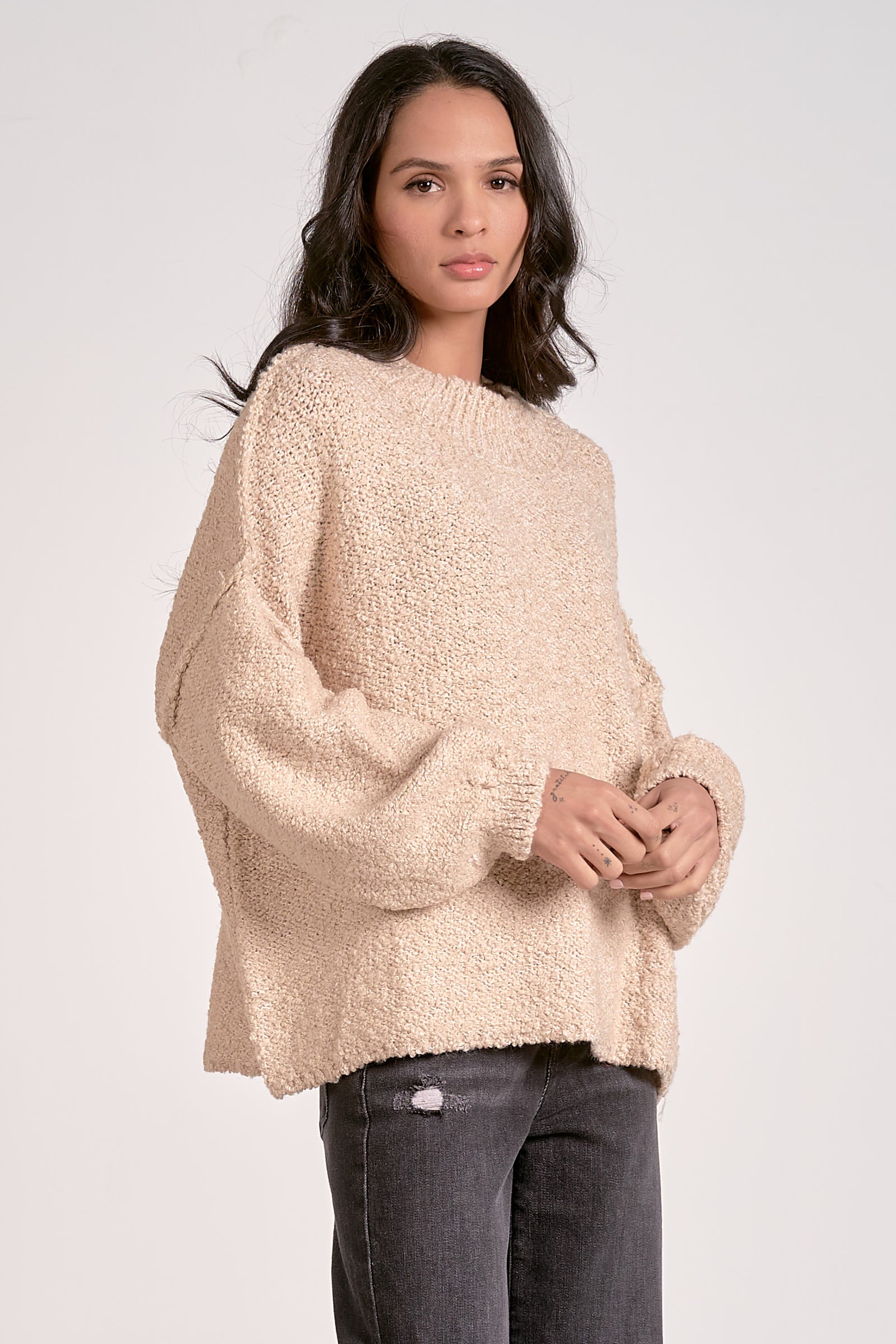 Woman wearing a beige sweater on a white background