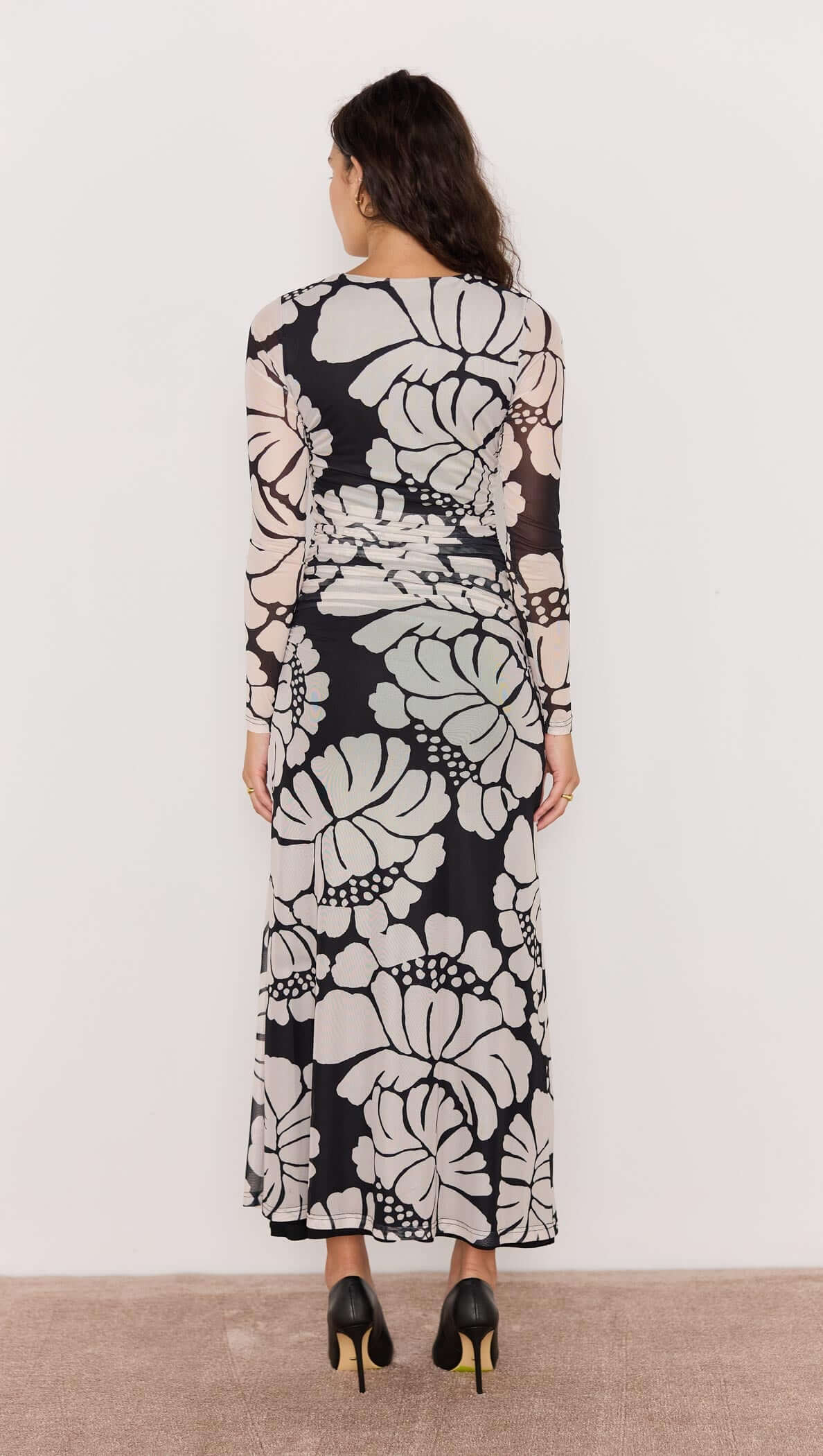 Woman wearing a long floral dress with a white background