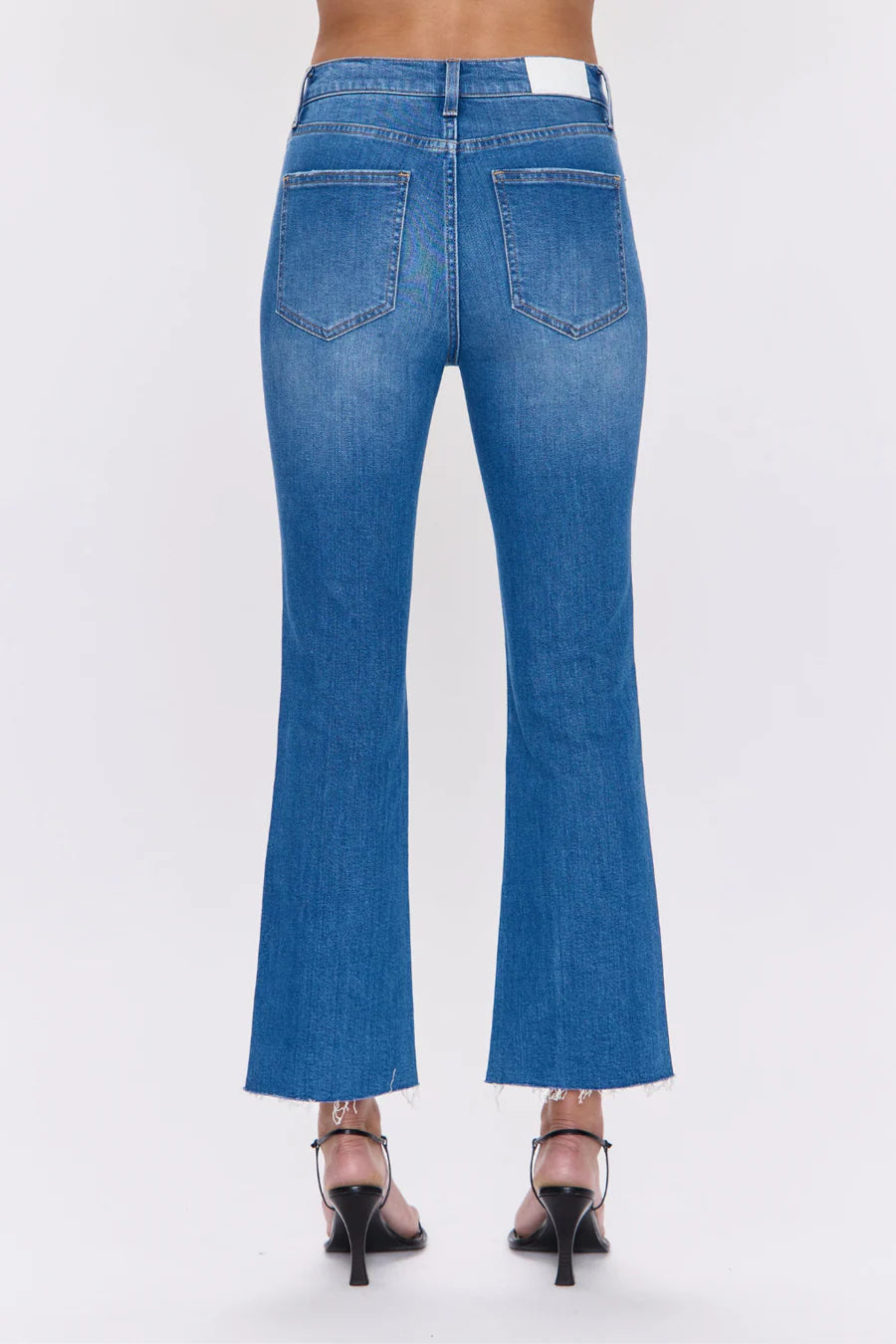 Blue jeans worn by a person on a white background