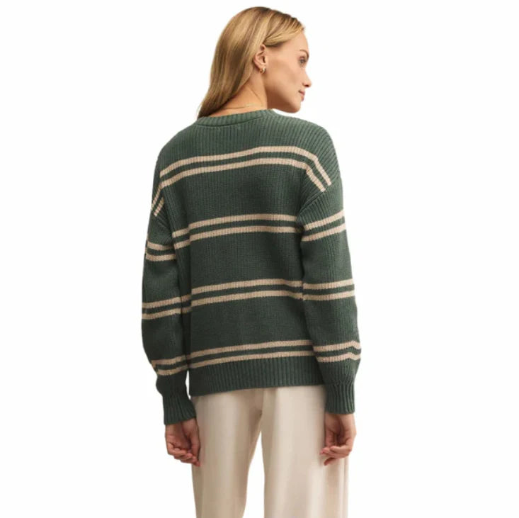 Woman wearing a green and beige striped sweater on a white background