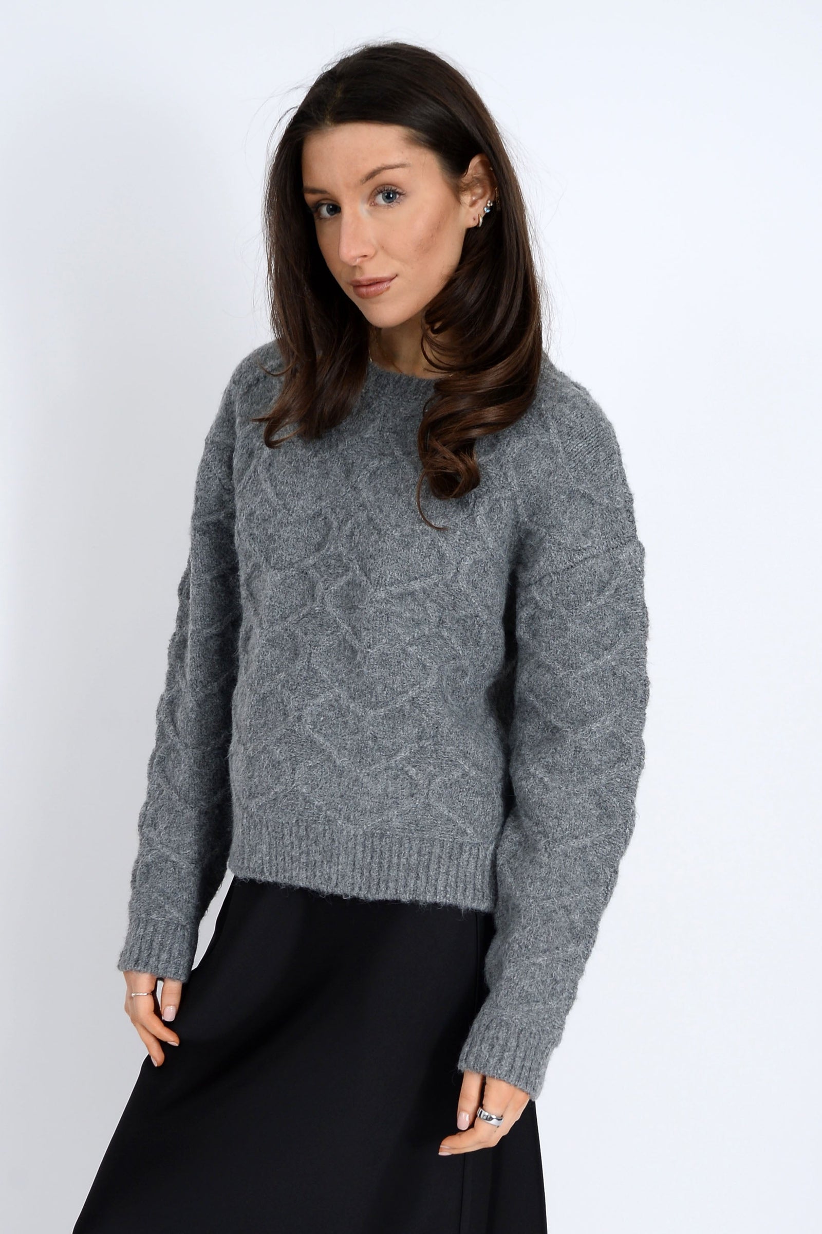 Woman wearing a gray sweater against a white background