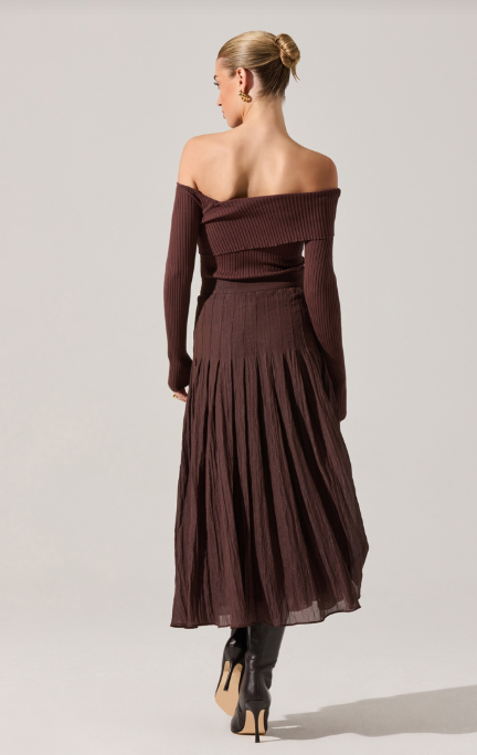 Woman wearing a brown off-shoulder dress on a light gray background