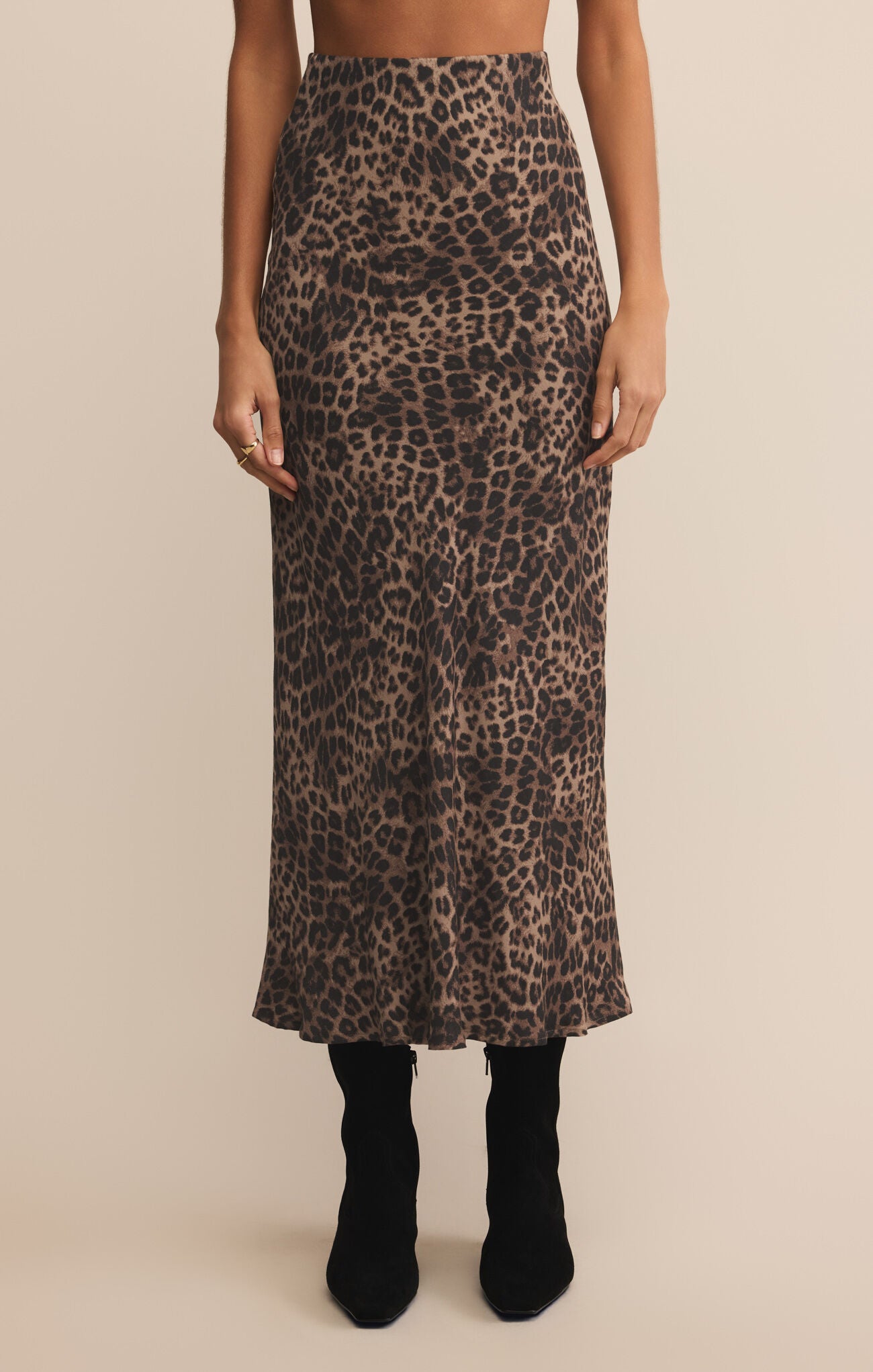 Leopard print skirt worn by a person on a beige background