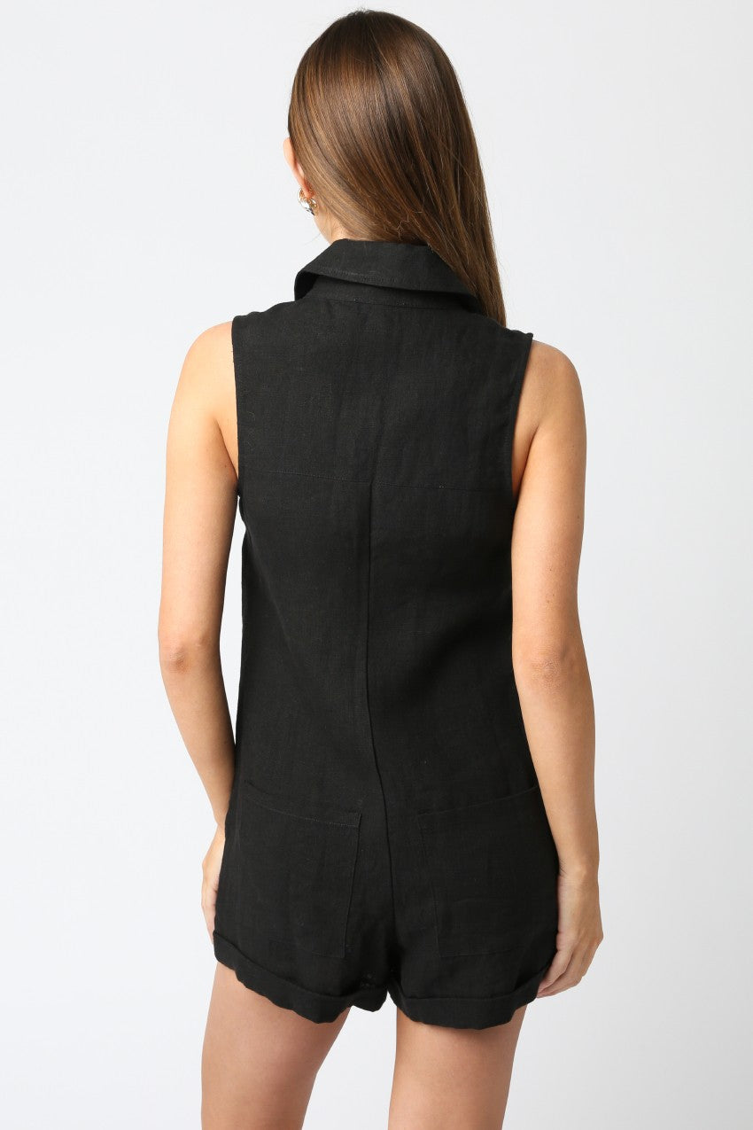 Woman wearing a black sleeveless romper on a white background