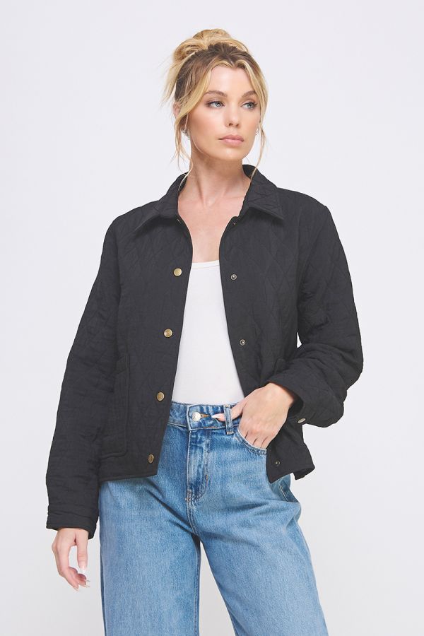 Woman wearing a black jacket and blue jeans on a white background