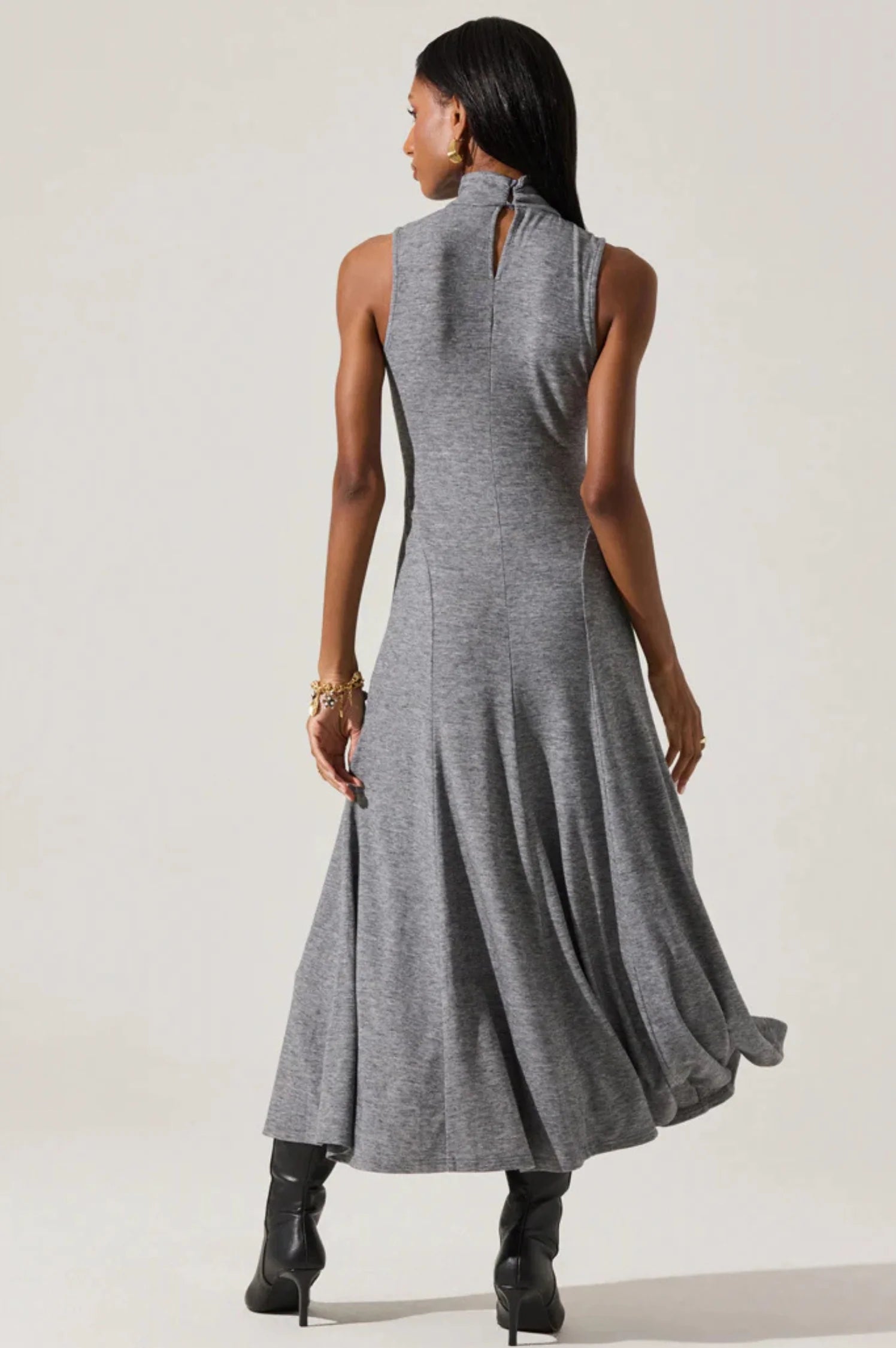 Woman wearing a gray sleeveless dress against a white background