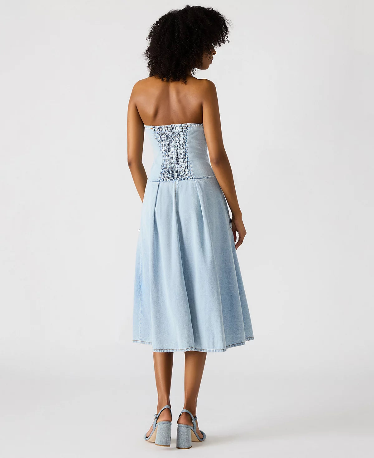 Woman wearing a light blue strapless dress with lace detailing on a white background