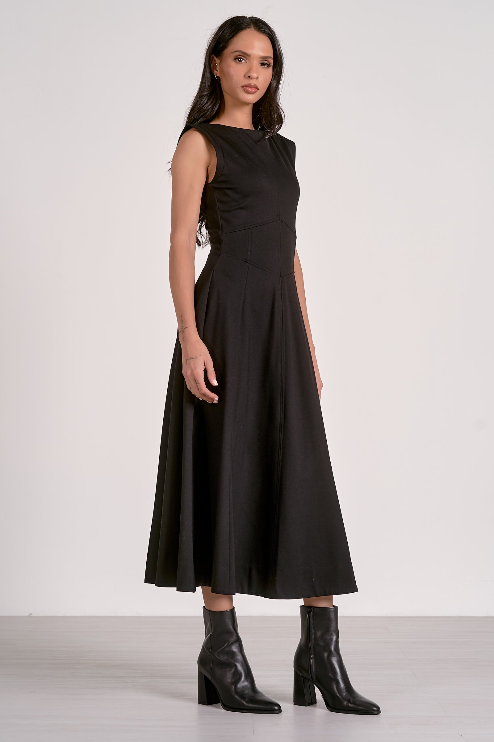 Woman wearing a black sleeveless dress with a white background