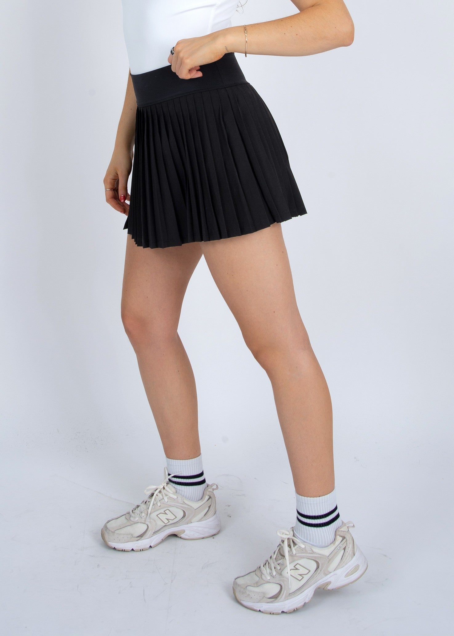 Front view of STMT BOUTIQUE YURA PLEATED MINI SKIRT in black