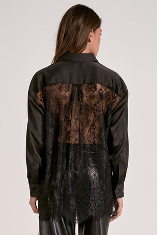 Black shirt with lace detailing on the back worn by a person against a white background