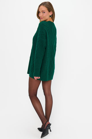 Woman wearing a green sweater dress on a white background