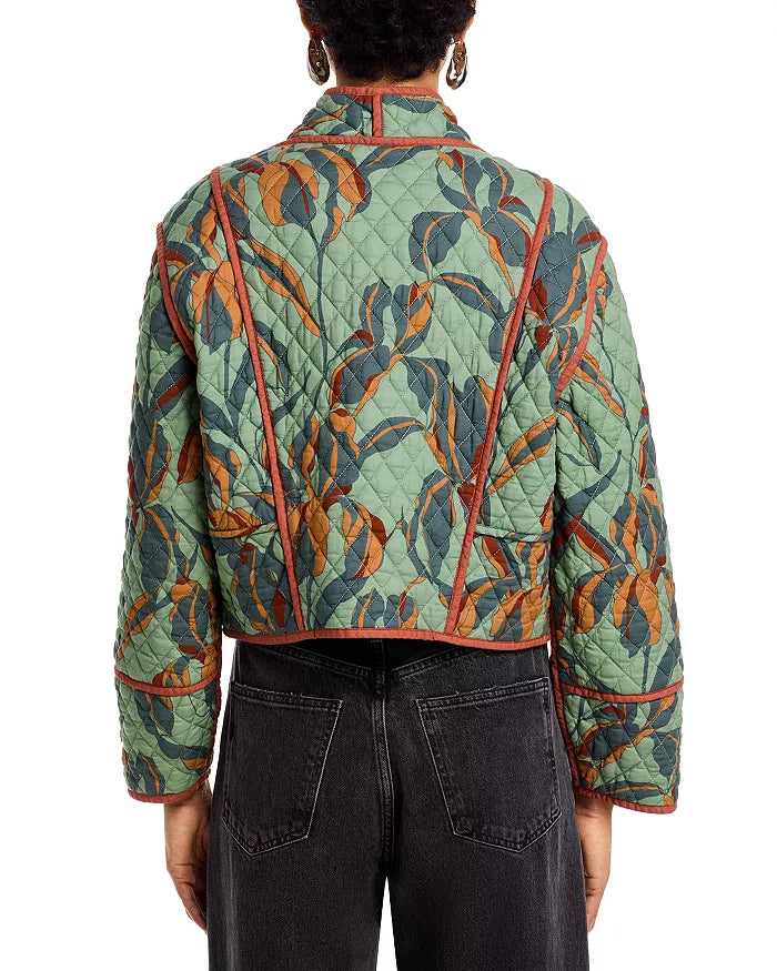 Person wearing a green quilted jacket with leaf pattern on a white background