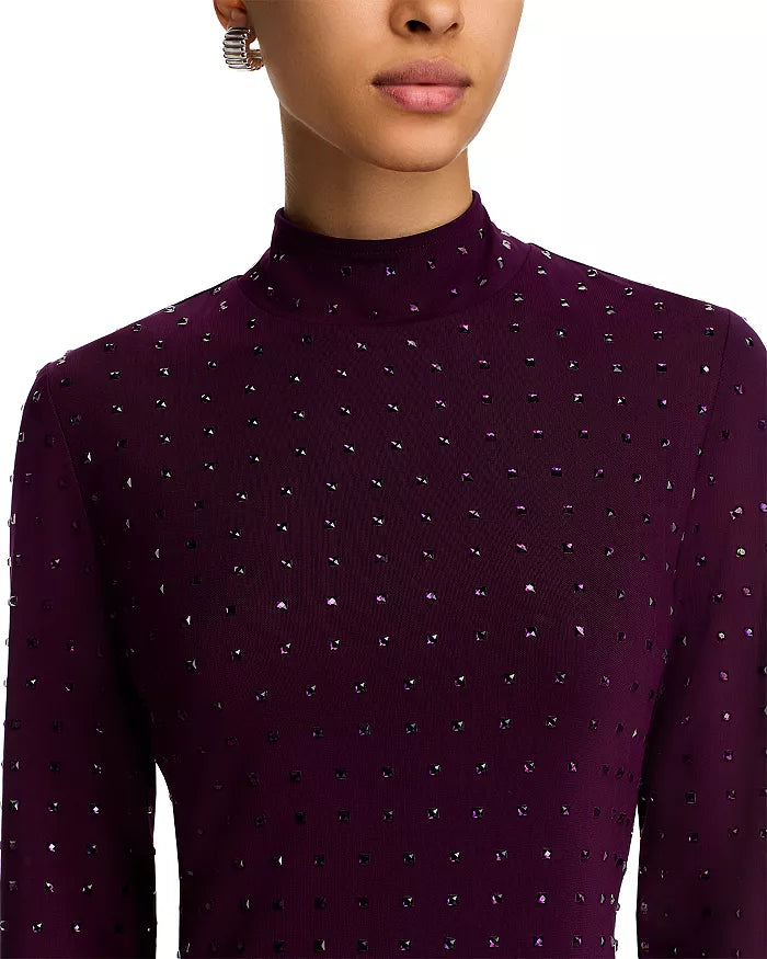 Close-up of a person wearing a dark purple turtleneck sweater with a subtle pattern.