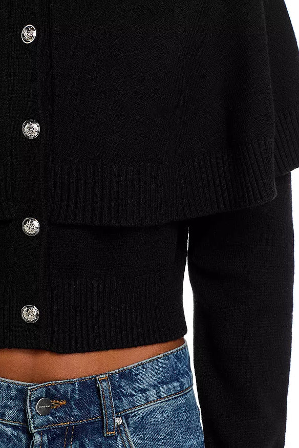 Black cardigan with silver buttons worn by a person, with a white background