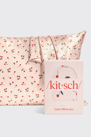 Satin pillowcase with cherry pattern and 'kitsch' packaging on a white background