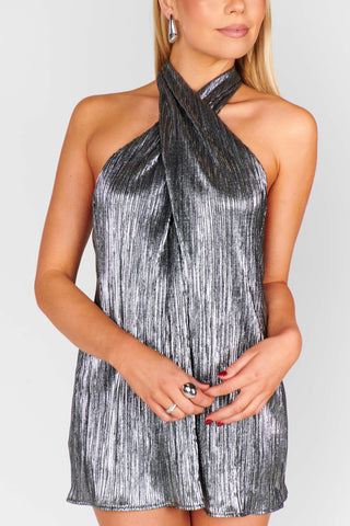 Woman wearing a silver and black halter dress against a white background