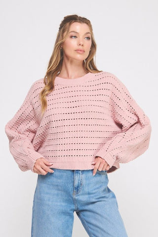 Woman wearing a pink sweater and blue jeans on a white background