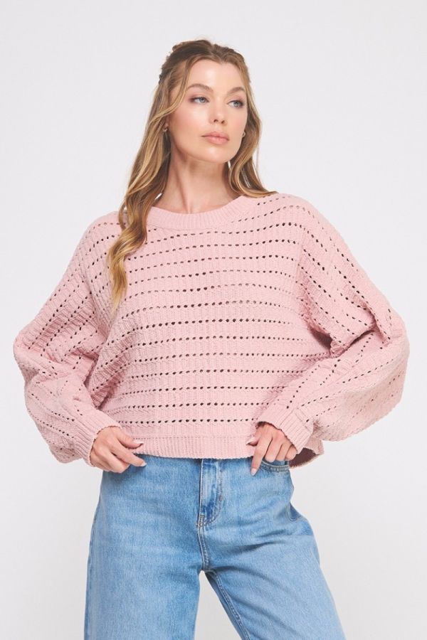 Woman wearing a pink sweater and blue jeans on a white background