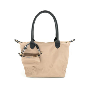 Beige tote bag with black handles and decorative straps on a white background