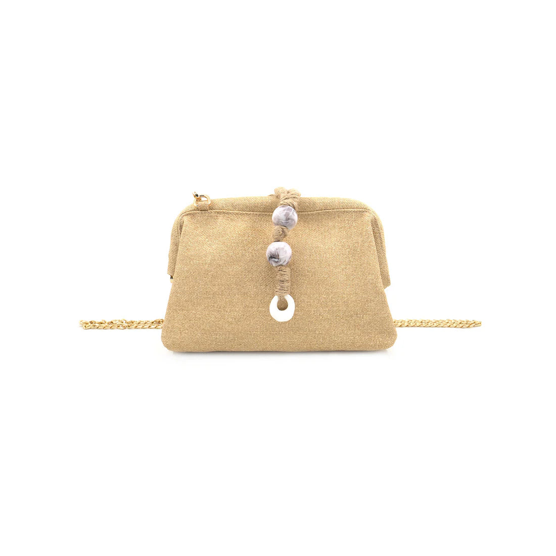Beige clutch bag with decorative buttons held by a hand against a natural background