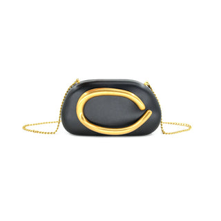 Black clutch with gold chain and decorative element on a white background