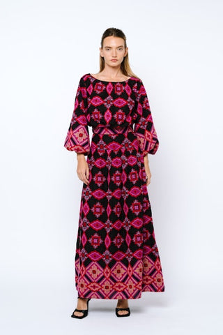 Woman wearing a long, patterned dress with a white background