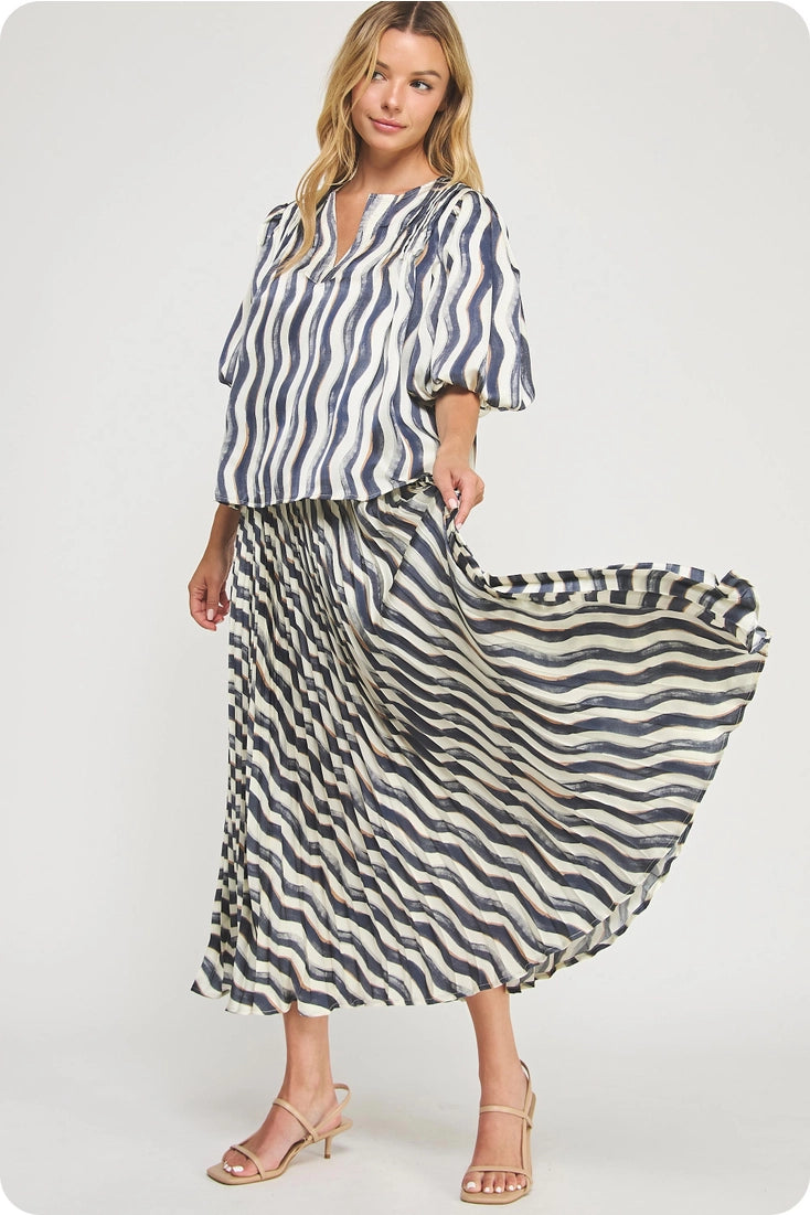 Woman wearing a blue and white striped top with a matching long skirt on a white background