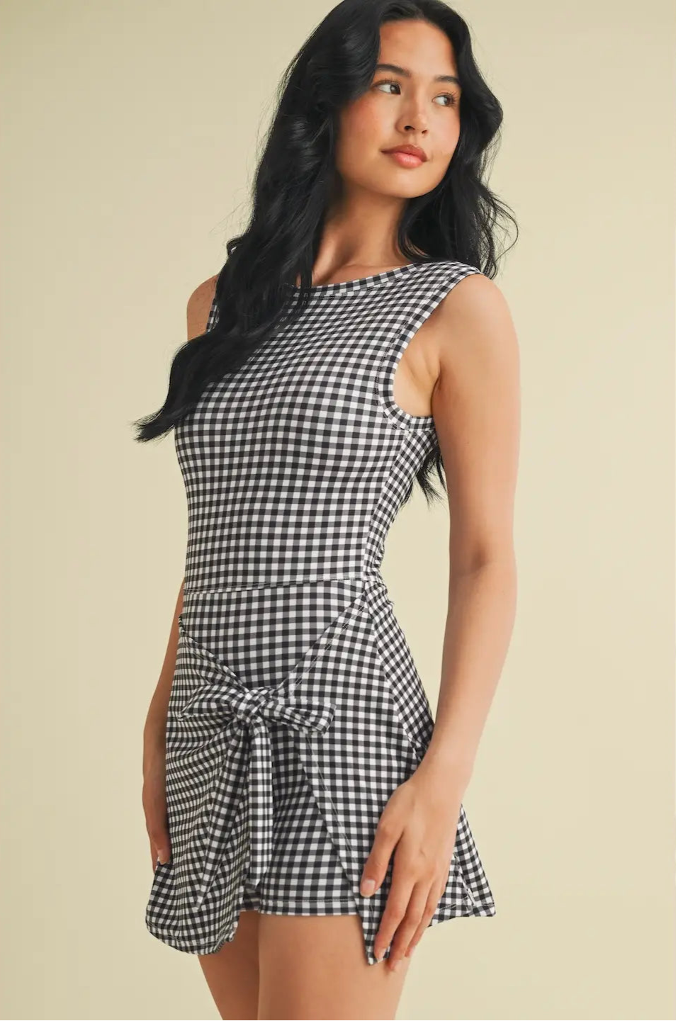 Woman wearing a black and white checkered dress on a beige background