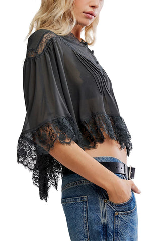 Black lace top worn by a person on a white background
