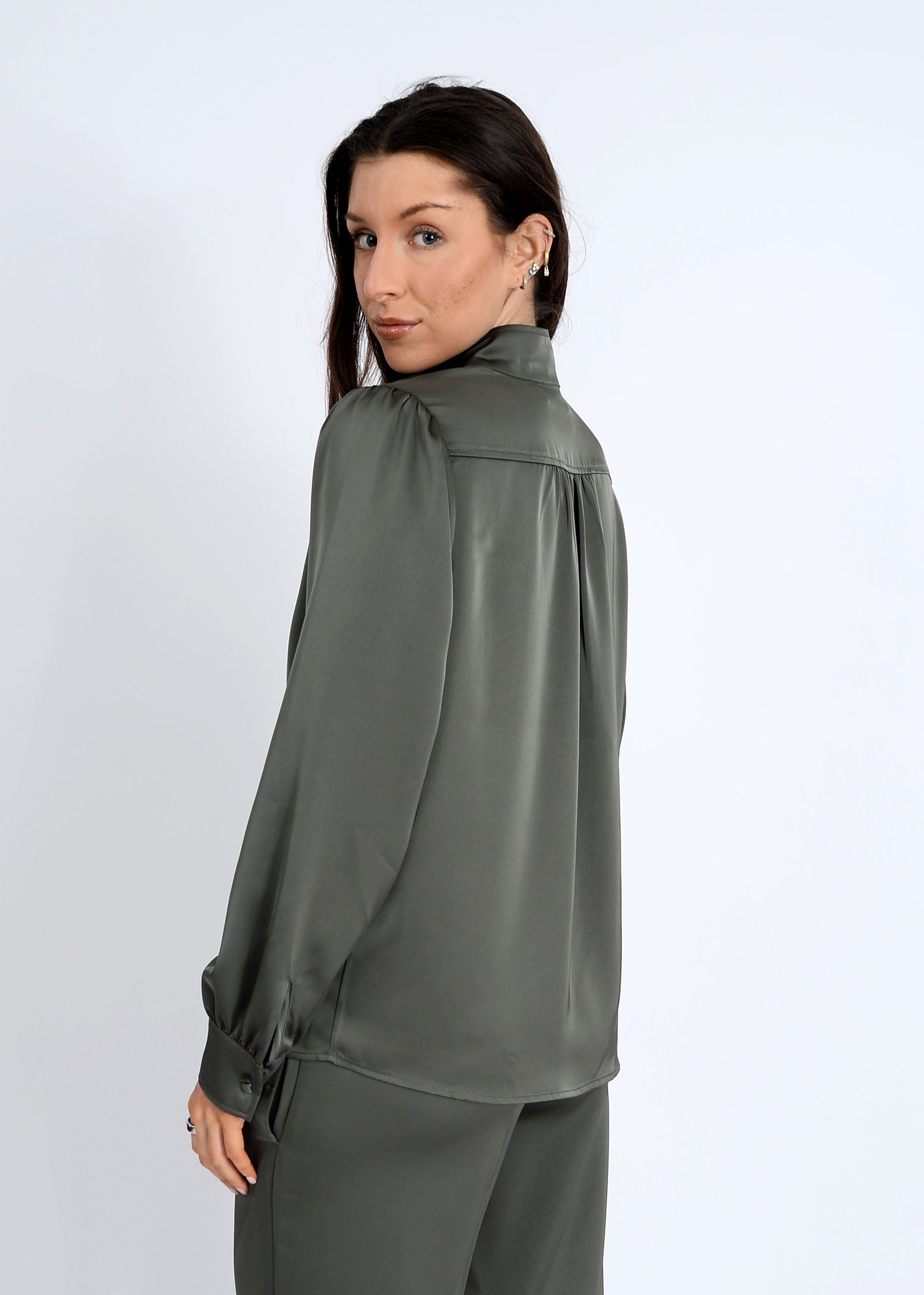 Woman wearing a green blouse against a white background