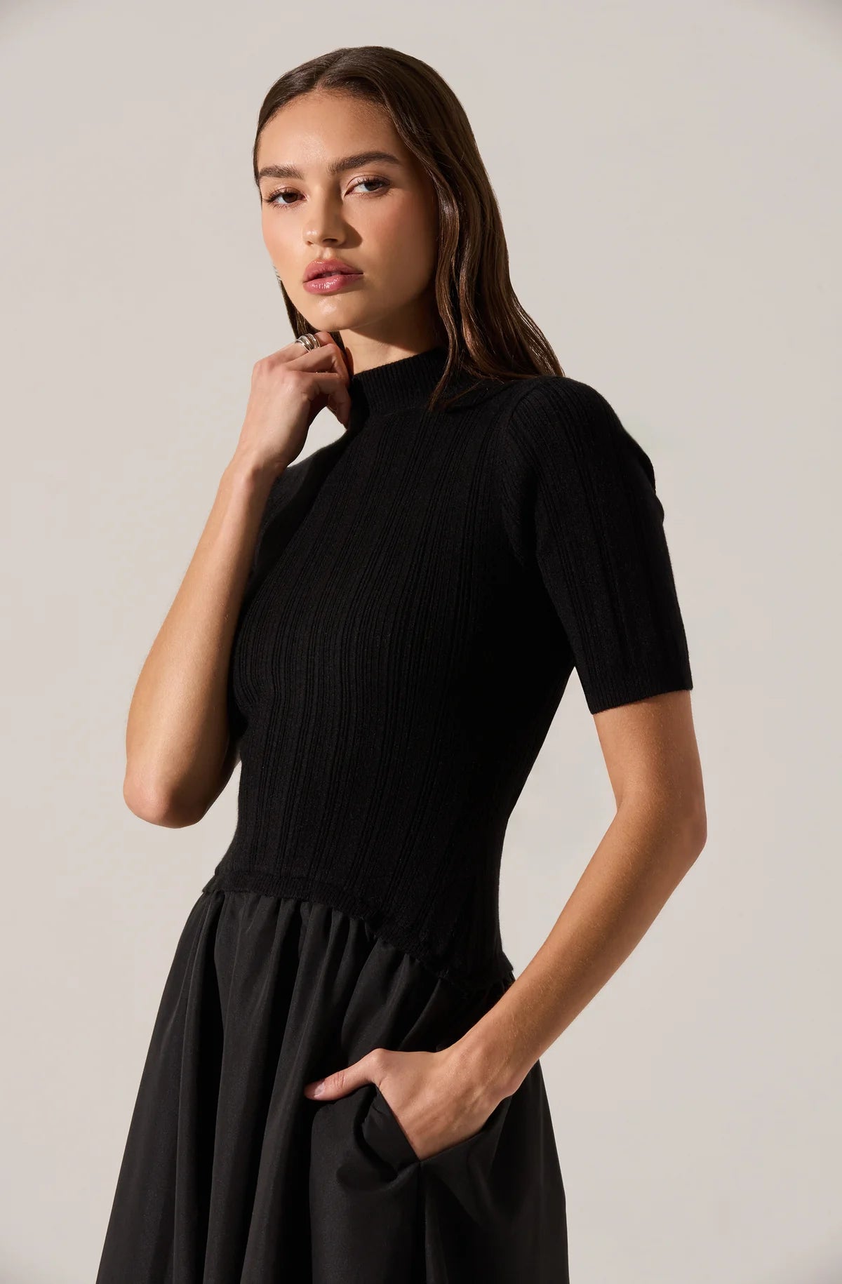 Woman wearing a black dress against a plain background