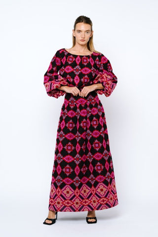 Woman wearing a patterned dress with puffed sleeves on a white background