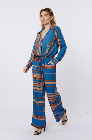 Woman wearing a blue and brown patterned jumpsuit on a white background