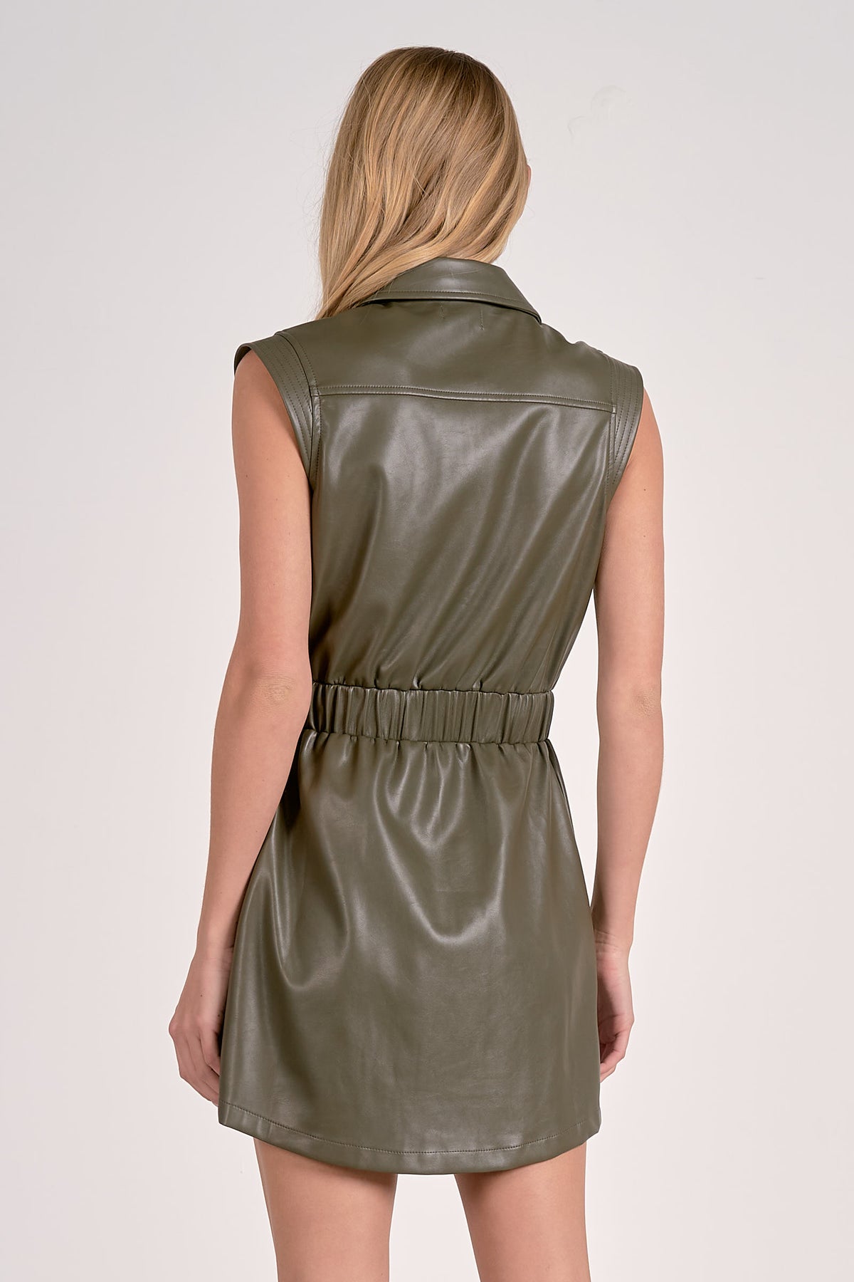 Green leather dress worn by a person on a white background