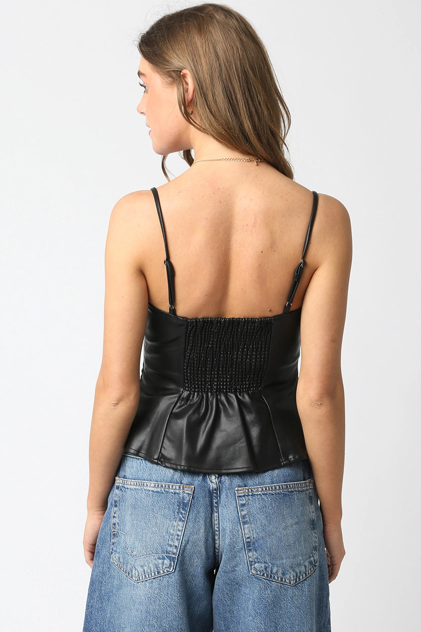 Woman wearing a black leather top and blue jeans on a white background