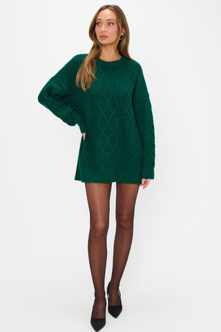 Woman wearing a green sweater dress on a white background