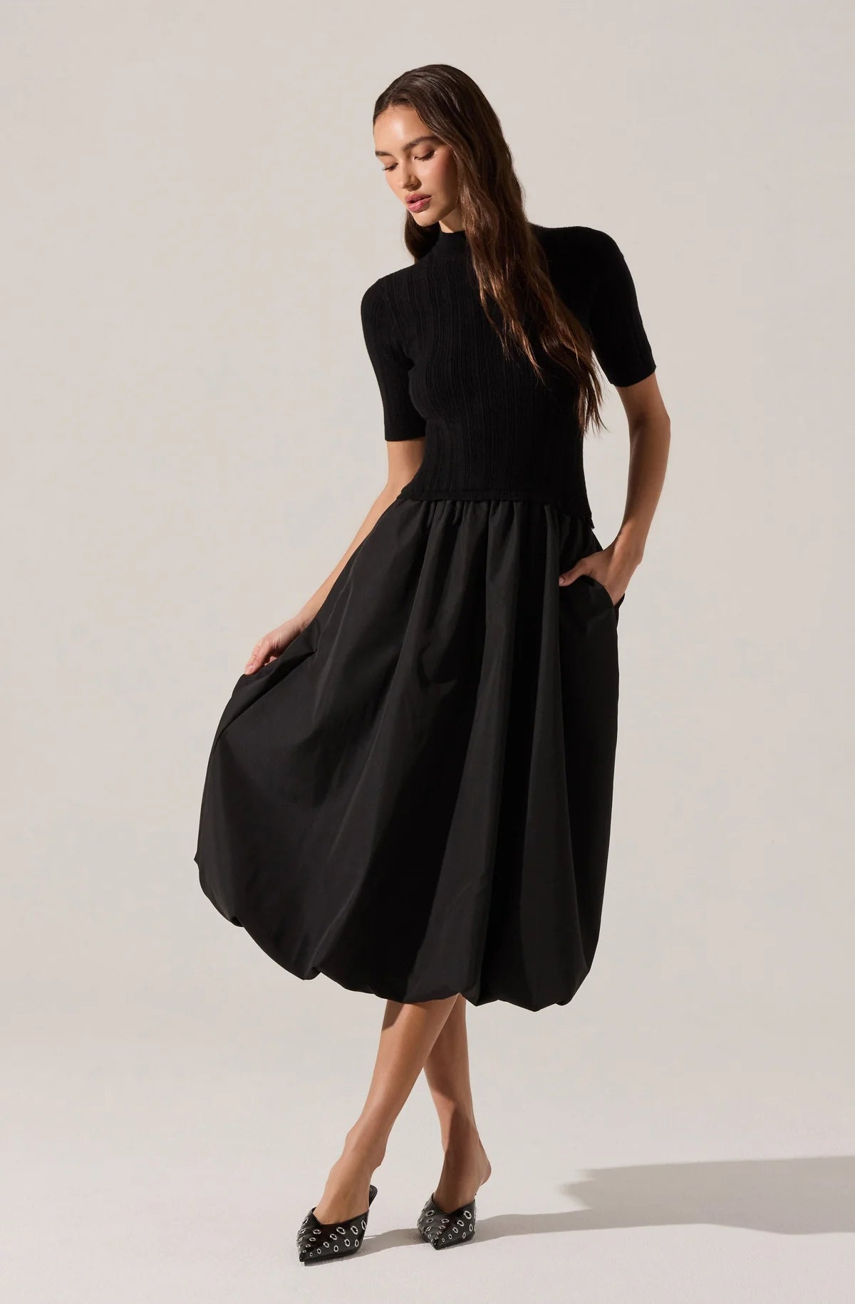 Woman wearing a black dress on a plain background