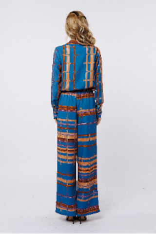 Woman wearing a blue and brown patterned outfit on a white background