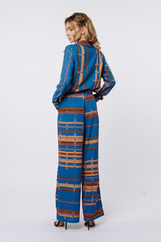 Woman wearing a blue and brown patterned outfit on a white background