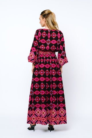 Woman wearing a long, patterned dress on a white background