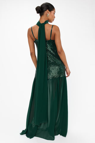 Woman wearing a green sequin dress with a white background