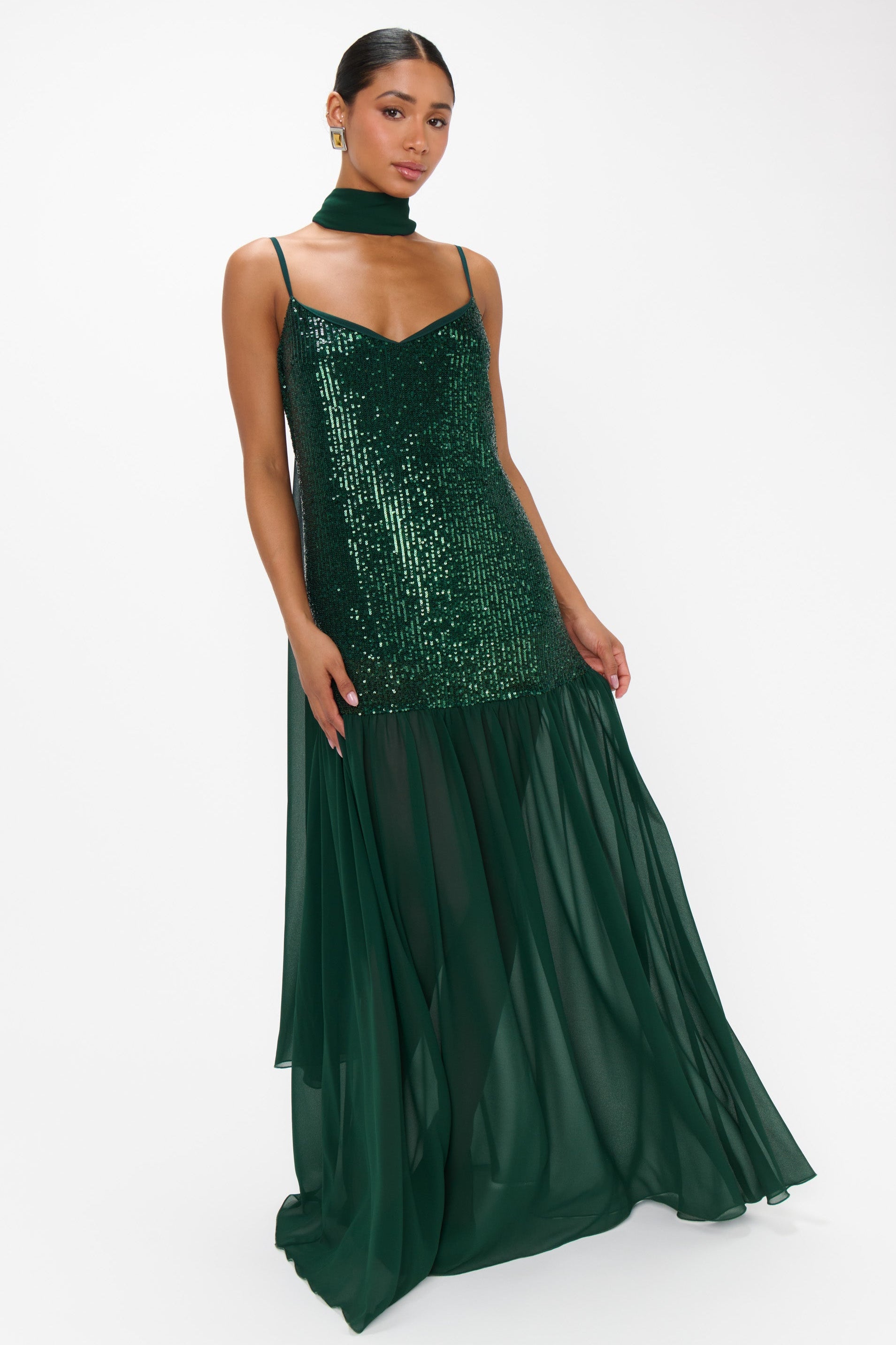 Woman wearing a green sequin dress on a white background