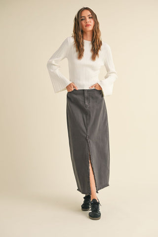 Woman wearing a white sweater and gray skirt on a beige background