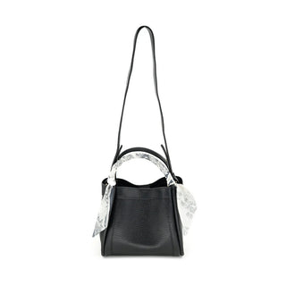 Black handbag with a decorative white scarf on a white background
