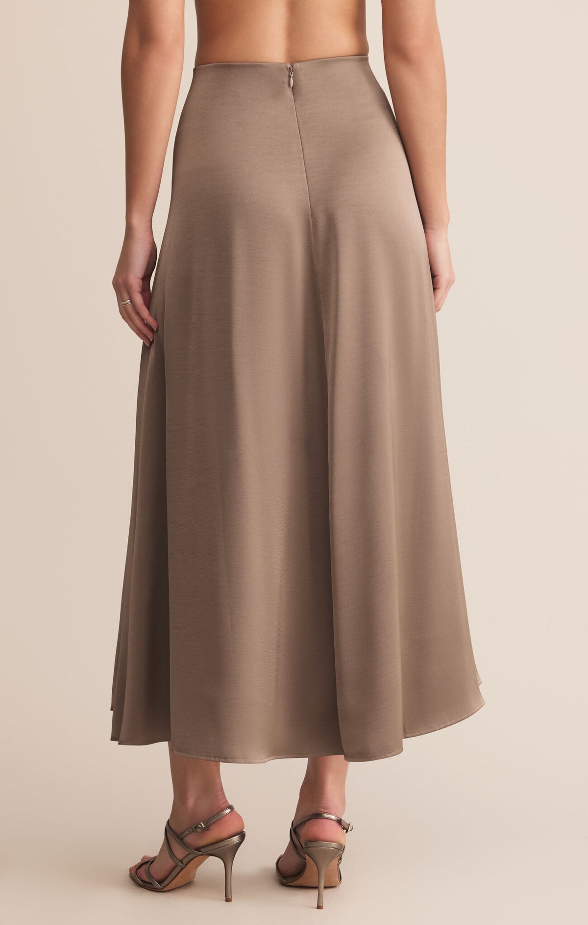 Brown skirt worn by a person on a beige background