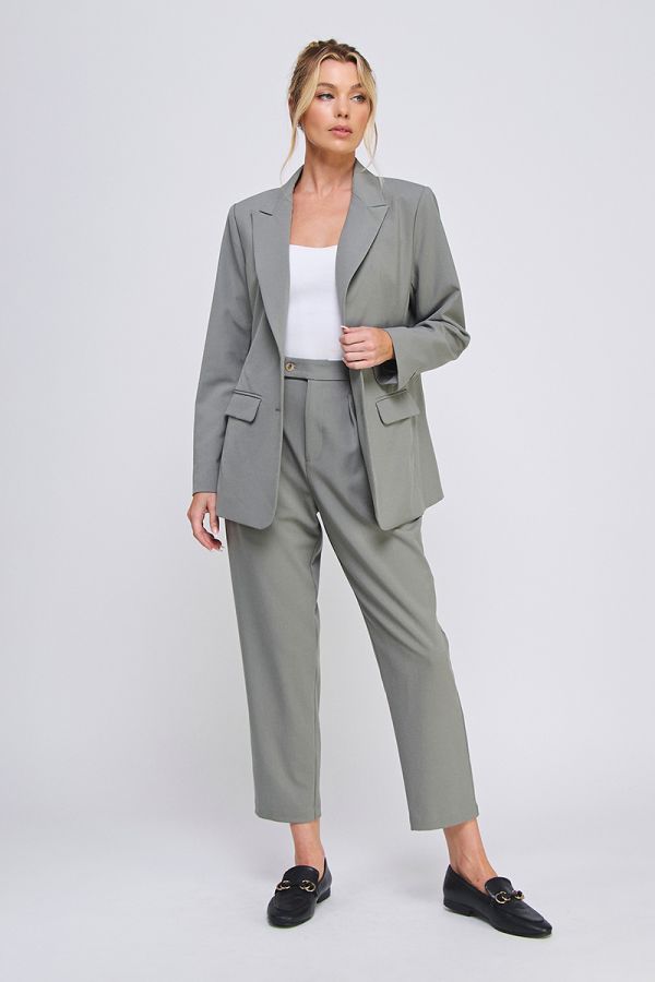 Woman wearing a gray suit with a white top on a light gray background