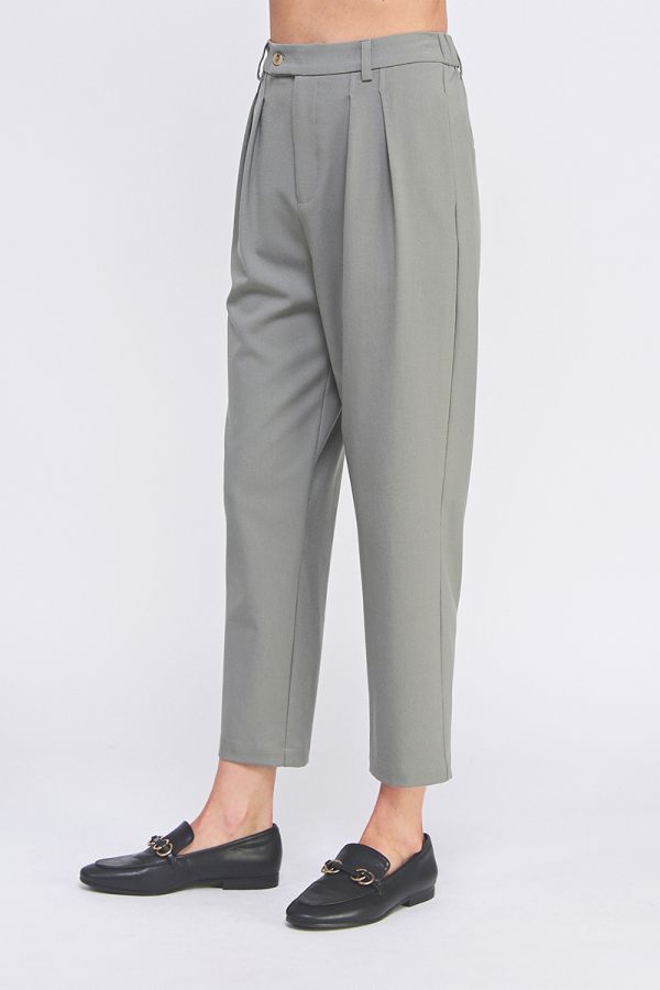 Gray pleated pants worn by a person on a white background